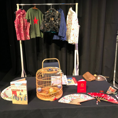 Chinese artefacts, including clothes, fans and a bamboo birdcage