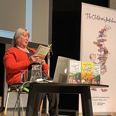 Hilary McKay on stage, reading an extract
