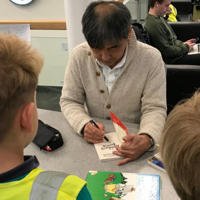 Satoshi signing books for the children after his performance
