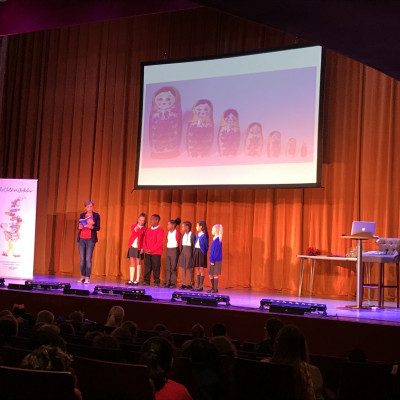 Rachel gets some children up onto stage, to help her perform her Russian Doll poem