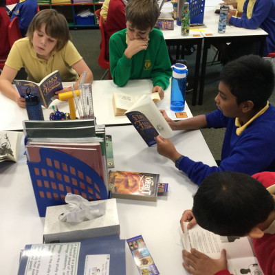 Children enjoying their free copies of *Stars with Flaming Tails* by Valerie Bloom