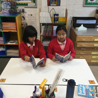 Children enjoying their free copies of *Stars with Flaming Tails* by Valerie Bloom