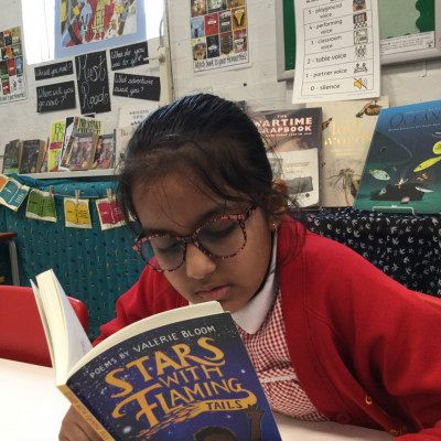 Children enjoying their free copies of *Stars with Flaming Tails* by Valerie Bloom