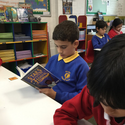 Children enjoying their free copies of *Stars with Flaming Tails* by Valerie Bloom